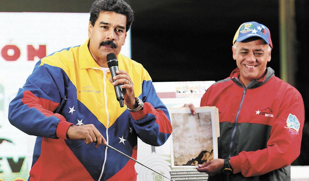 Venezuelan president Nicolas Maduro (L) and Jorge Rodriguez, mayor of Libertador Caracas municipality, show a picture taken by workers in a tunnel showing an alleged visage of late President Hugo Chavez, in Caracas on October 30, 2013. Hugo Chavez may hav