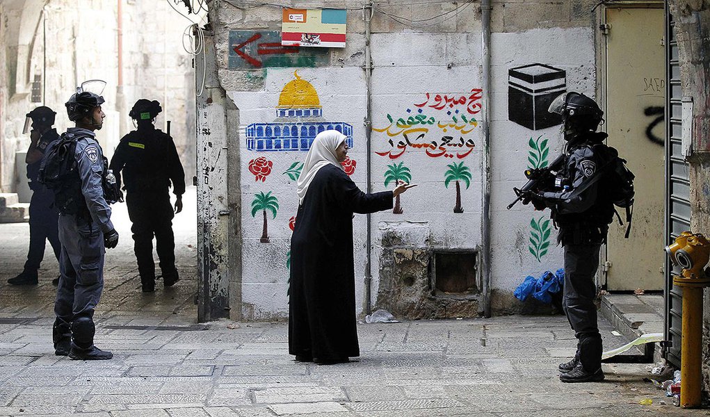 Palestina fala com policial israelense na Cidade Velha de JerusalÃ©m. 30/10/2014     REUTERS/Finbarr O'Reilly