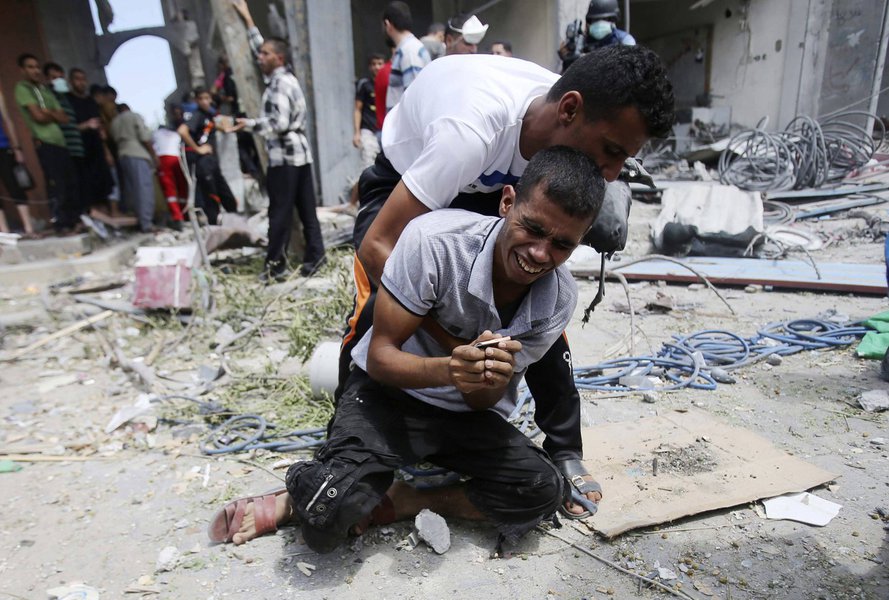 Palestino se desespera depois que corpo da mãe foi encontrado nos escombros de casa que, segundo testemunhas, foi derrubada por ataque de Israel na Faixa de Gaza. 04/08/2014  REUTERS/Ibraheem Abu Mustafa