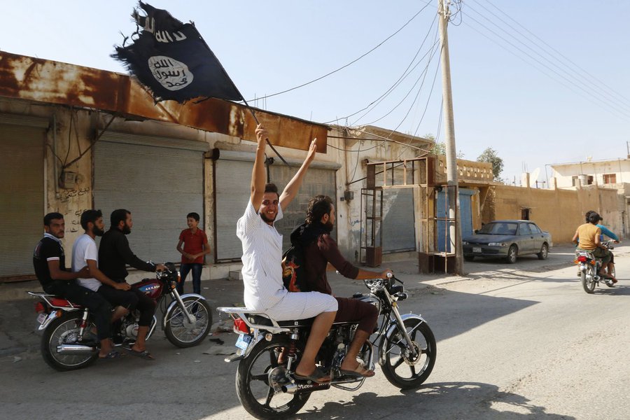 Moradores de Tabqa erguem bandeira do Estado Islâmico perto de Raqqa. 24/08/2014 REUTERS/Stringer