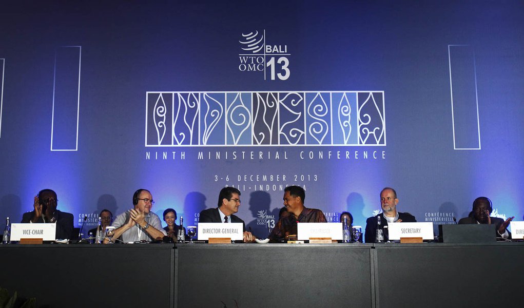 Director-General Roberto Azevedo (centre L) shake hands with Conference Chairman Gita Wirjawan as they declare the ceremonial closing of the ninth World Trade Organization (WTO) Ministerial Conference in Nusa Dua, on the Indonesian resort island of Bali D
