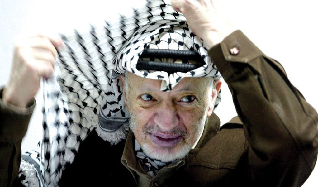 (FILES) This file photo dated 12 April 2...RAMALLAH, -:  (FILES) This file photo dated 12 April 2003 shows Palestinian leader Yasser Arafat adjusting his head-dress, keffiyeh, during a meeting in his Ramallah office. It was announced 11 November 2004 that