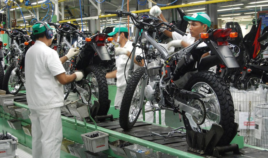 Operários da Honda trabalham em linha de montagem de motocicleta na Zona Franca de Manaus, AM, um dos principais polos industriais do Brasil. 