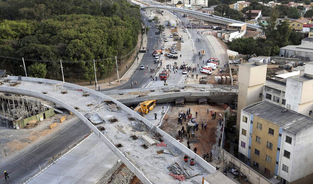 Rescue workers try to reach vehicles trapped underneath a bridge that collapsed while under construction in Belo Horizonte July 3, 2014. An unfinished overpass collapsed in the Brazilian World Cup host city of Belo Horizonte on Thursday, killing at least 