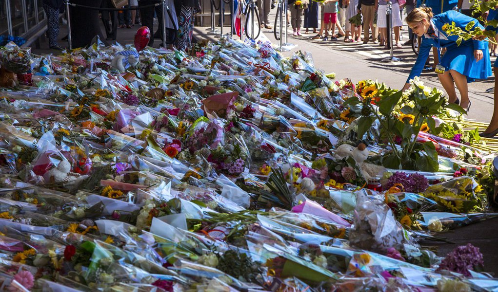 Comissária de bordo da empresa KLM  deposita flor no aeroporto de Schiphol, em Amsterdã, no dia de luto pela morte dos passageiros do avião da Malaysia Airlines.  REUTERS/Cris Toala Olivares