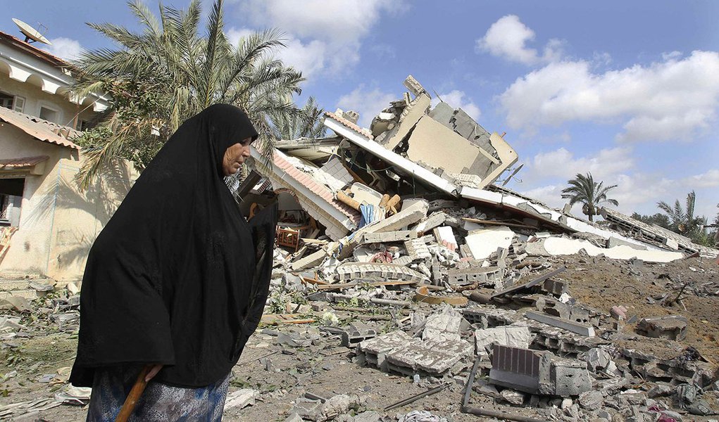 Palestina passa por destroÃ§os de casa que polÃ­cia diz que foi destruÃ­da por ataque israelense em Gaza. 15/07/2014 REUTERS/Ahmed Zakot