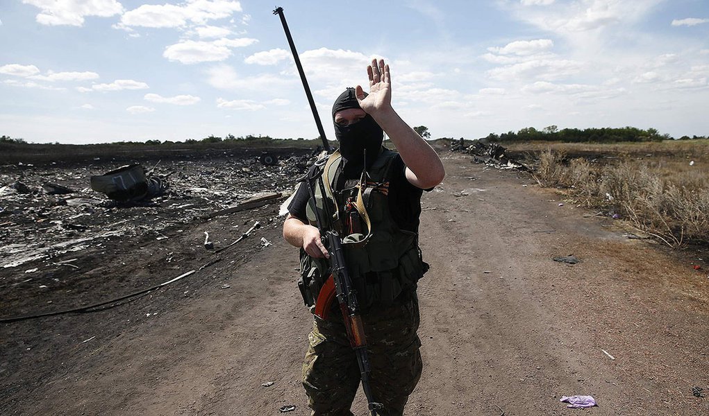 Um separatista prÃ³-RÃºssia armado acena para repÃ³rteres no local da queda do aviÃ£o da Malaysia Airlines, perto de Grabovo, na regiÃ£o de Donetsk, leste da UcrÃ¢nia, nesta segunda-feira. 21/07/2014 REUTERS/Maxim Zmeyev