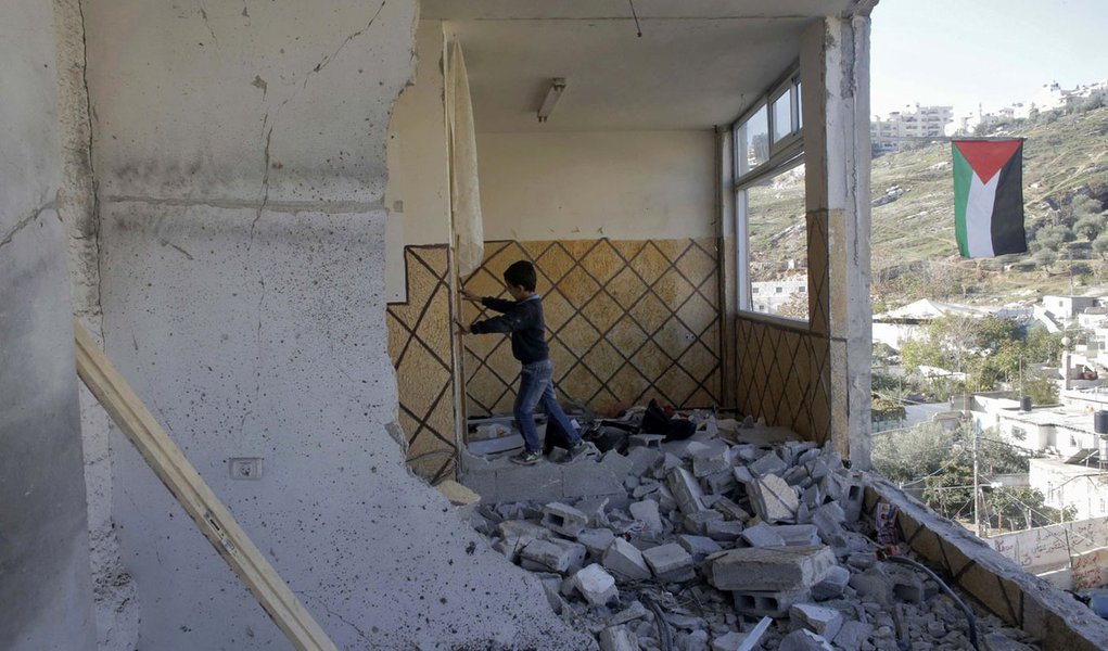 Menino palestino, familiar de Abdel-Rahman Shaloudi, sobre os escombros da casa destruÃ­da de Shaloudi em JerusalÃ©m Oriental. 19/11/2014 REUTERS/Ammar Awad