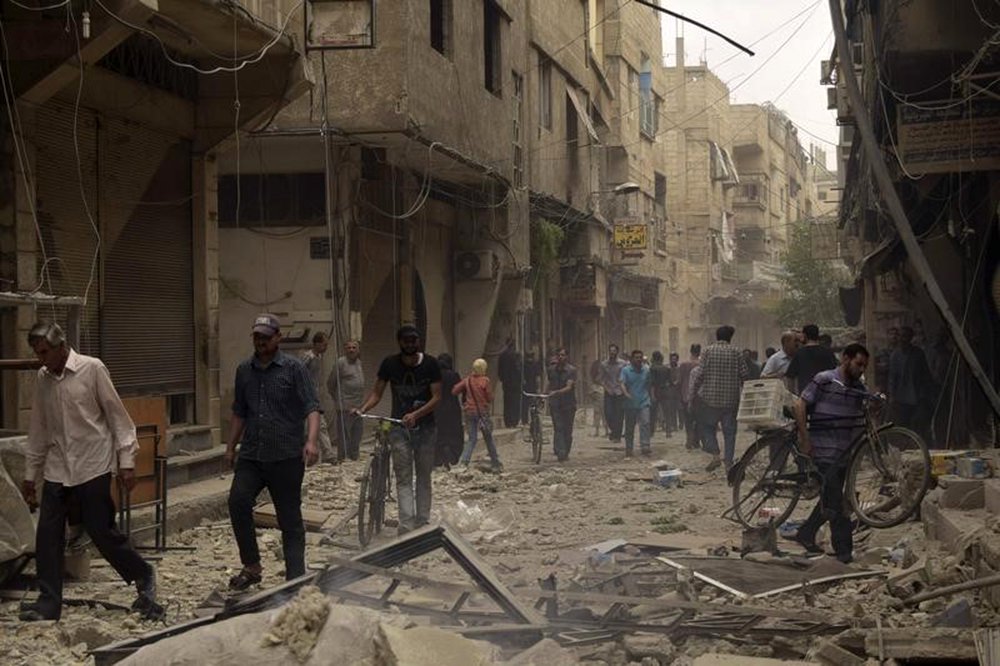 Pessoas em rua destruída por ataques aéreos, na cidade de Arbeen, Síria. 27/05/2015 REUTERS/Yousef Homs