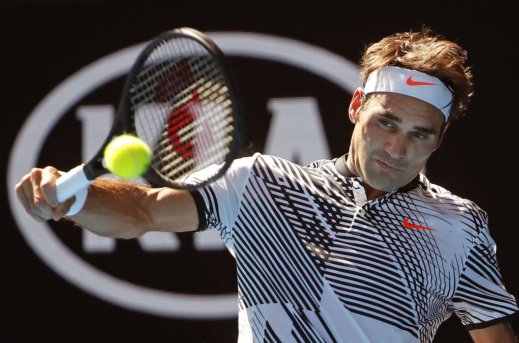 Switzerland's Roger Federer makes a backhand return to United States'