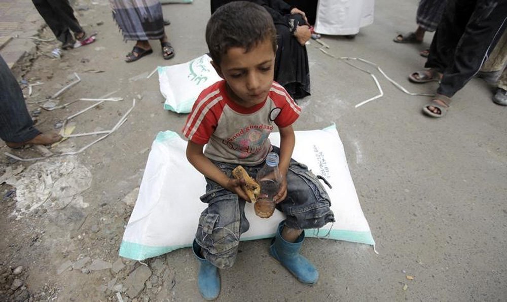 CrianÃ§a comendo enquanto recebe ajuda de programa da ONU, no IÃªmen. 02/07/2012    REUTERS/Mohamed al-Sayaghi