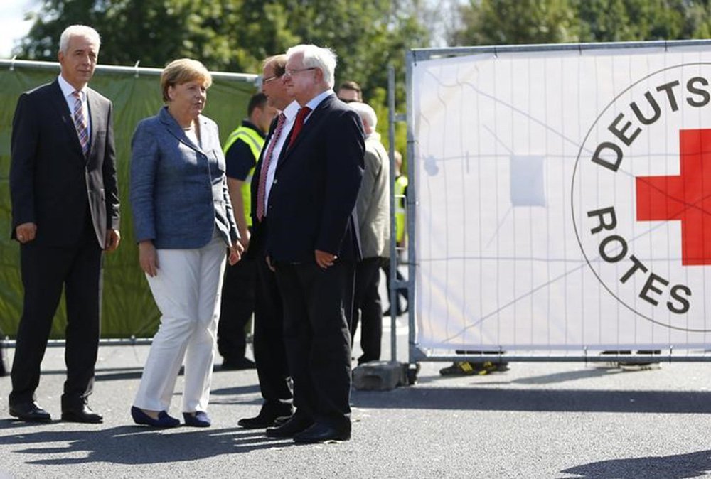 Chanceler alemã, Angela Merkel, e presidente da Cruz Vermelha na Alemanha, Rudolf Seiters (à esquerda), chegam a abrigo para refugiados em Heidenau. 26/8/2015 REUTERS/Axel Schmidt
