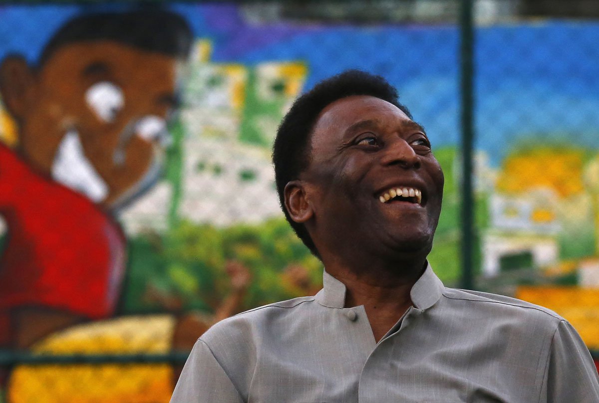 Brazilian soccer legend Pele laughs during the inauguration of a refurbished soccer field at the Mineira slum in Rio de Janeiro September 10, 2014. The soccer pitch was refurbished by Anglo-Dutch oil company Royal Dutch Shell using underground tiles which