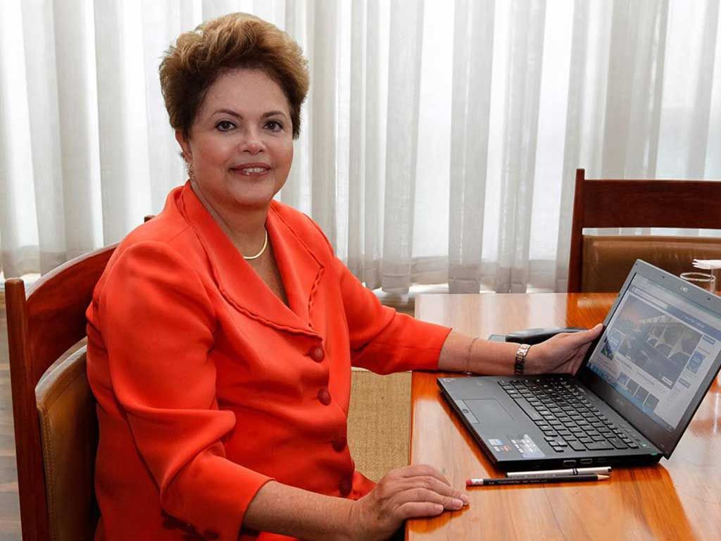 Ministros entenderam que a presidente Dilma Rousseff não cometeu irregularidade ao fazer uma conversa virtual, por meio da rede social Facebook, em julho, para falar sobre o Programa Mais Médicos; ação foi proposta pelo candidato Aécio Neves (PSDB), que pediu aplicação de multa entre R$ 5 mil e R$ 100 mil