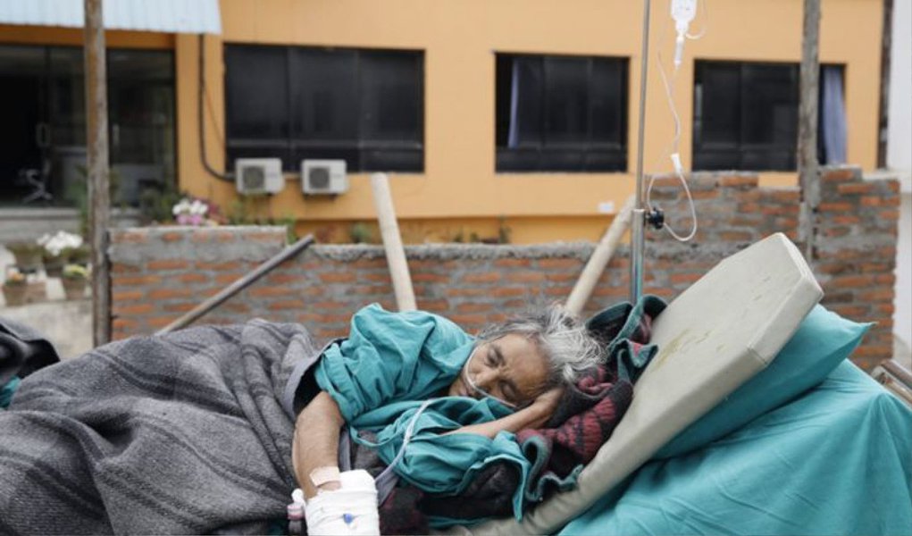 Médicos sobrecarregados moviam centenas de pacientes para as ruas da capital do Nepal enquanto tremores secundários sacudiam hospitais e edifícios já danificados pelo terremoto que matou mais de 2.400 pessoas e devastou o Vale de Kathmandu; doentes e feridos deitavam-se em uma empoeirada rodovia fora do Kathmandu Medical College, enquanto funcionários do hospital carregavam pacientes para fora do prédio em macas e sacos; as Nações Unidas informaram que equipes enviadas por EUA, China, Israel, Índia e Paquistão chegaram ao Nepal para ajudar, escavando toneladas de escombros em busca de milhares de pessoas ainda desaparecidas