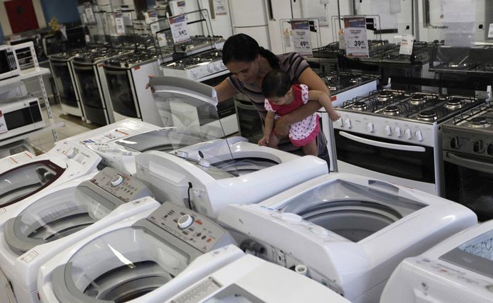 Uma mulher e sua filha olham uma máquina de lavar em uma loja da Casas Bahia, em São Paulo. O Índice de Confiança do Consumidor (ICC) da Fundação Getulio Vargas registrou ligeiro avanço de 0,1 por cento em março na comparação com fevereiro, interrompendo 