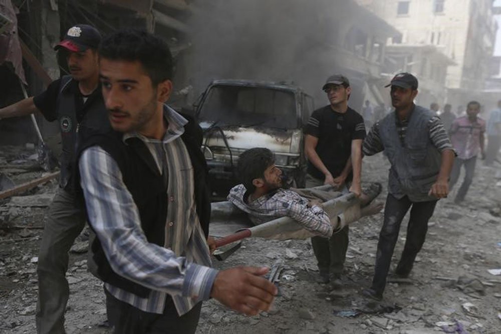 Moradores levam homem ferido por ataque aÃ©reo das forÃ§as do presidente sÃ­rio, Bashar al-Assad, em mercado de Douma, perto de Damasco, segundo ativistas. REUTERS/Bassam Khabieh