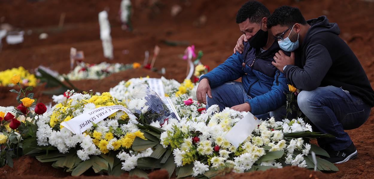 Familiares de mulher que morreu vítima da Covid-19 choram durante enterro em cemitério Vila Formosa, em São Paulo