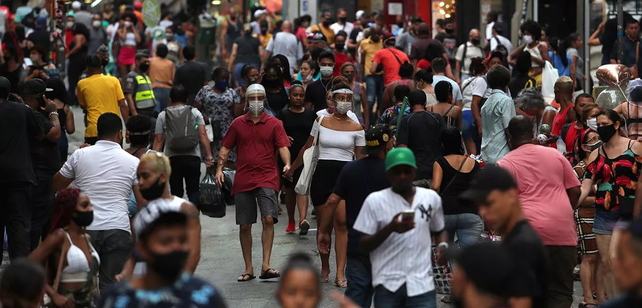 Pessoas caminham por rua de comércio popular no centro de São Paulo