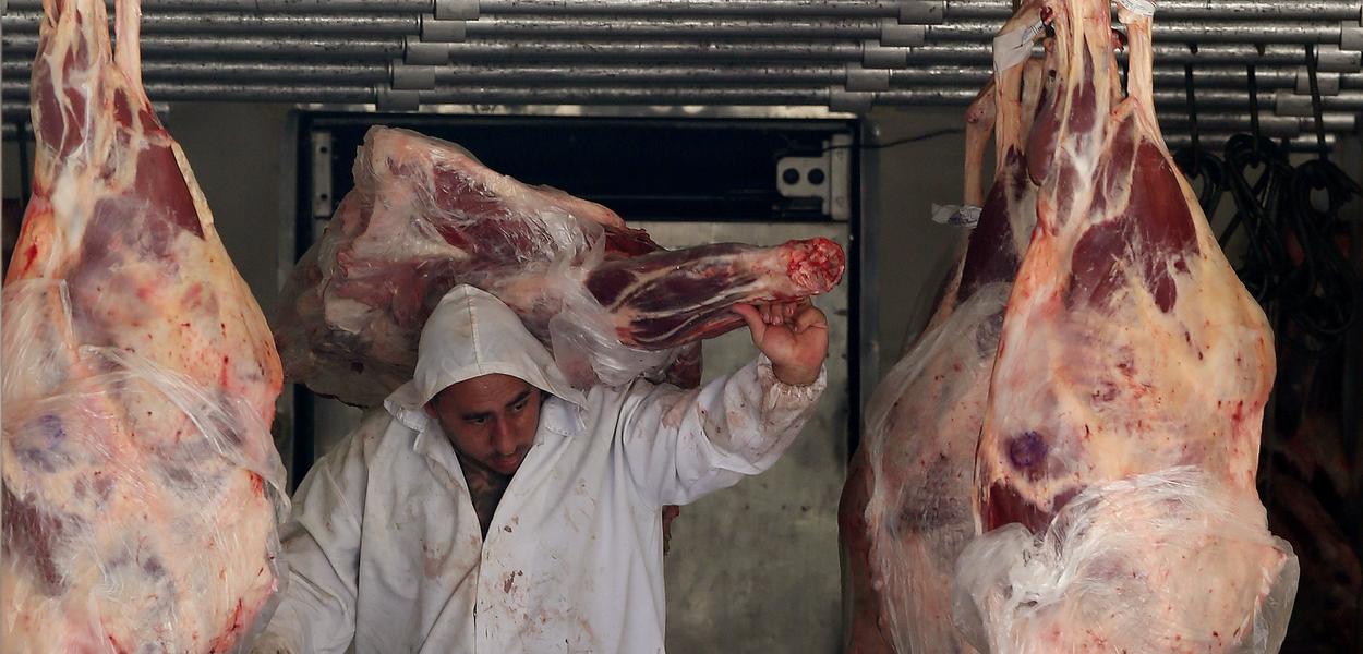 Trabalhador descarrega carne em açougue