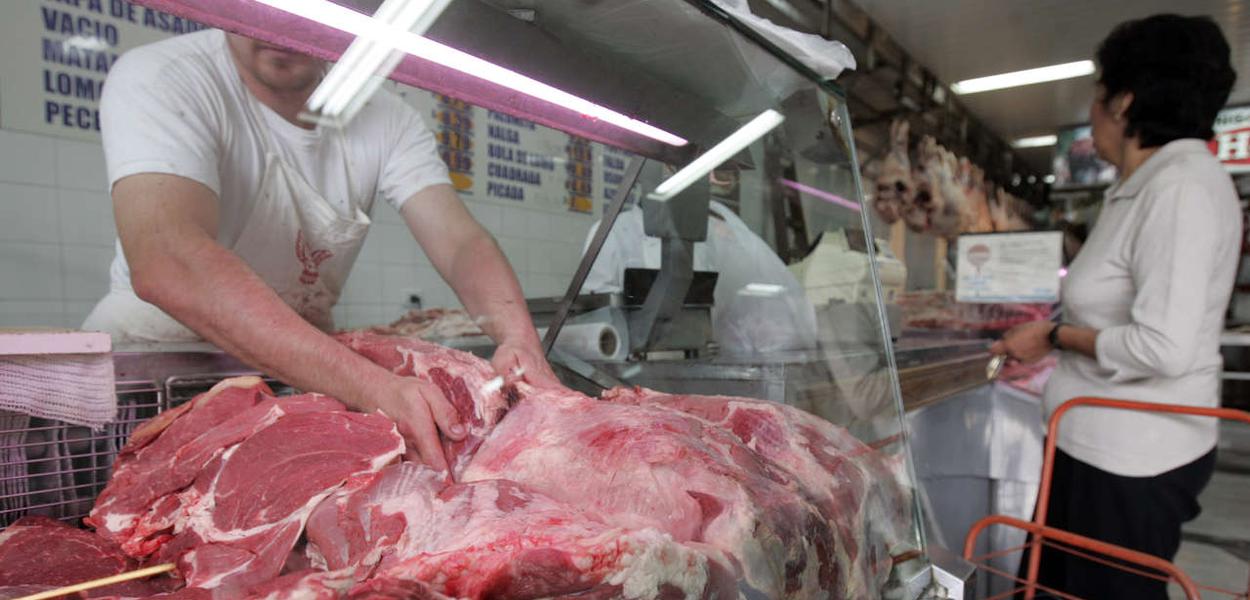Funcionário carrega pedaços de carne em açougue de São Paulo