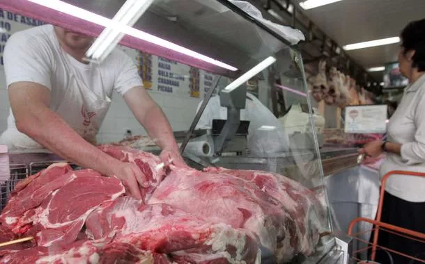 Funcionário carrega pedaços de carne em açougue de São Paulo 