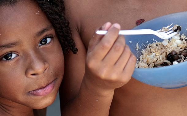 Thawanny Silva de Souza, de 6 anos, (E) e Rafael Silva de Souza, de 9 anos, (D), comem prato com arroz, feijão e ovo na Favela do Arci-Íris, em Recife 15/09/2022