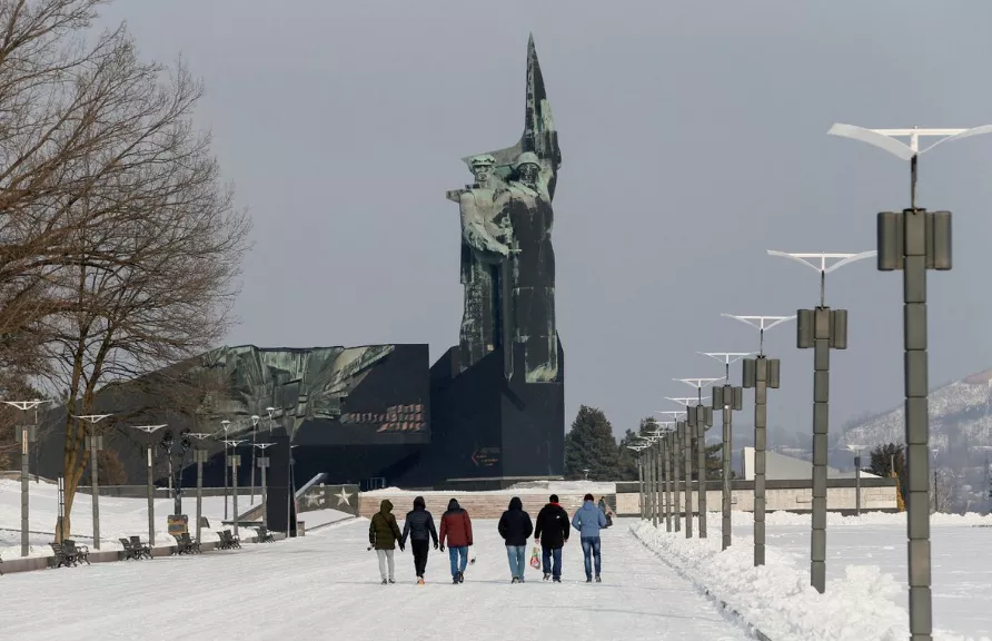 Pessoas caminham em direção a um monumento aos Libertadores de Donbass, em Donetsk