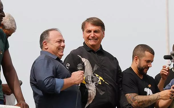 Eduardo Pazuello (com microfone na mão) e Jair Bolsonaro (agasalho preto)