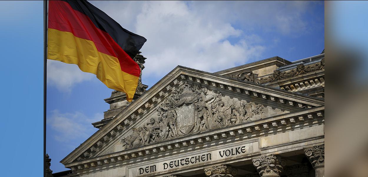 Uma bandeira alemã tremula no prédio do Reichstag, sede da câmara baixa do parlamento alemão