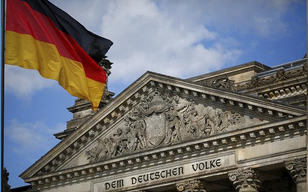 Uma bandeira alemã tremula no prédio do Reichstag, sede da câmara baixa do parlamento alemão