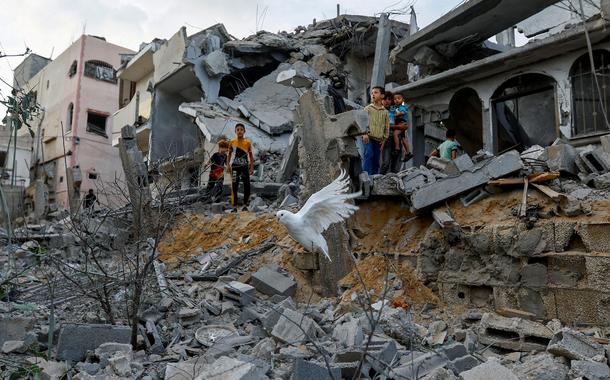 Pomba voa sobre os destroços de casas destruídas por ataques israelenses, em Khan Younis, no sul da Faixa de Gaza
11-10-2023
REUTERS/Ibraheem Abu Mustafa
