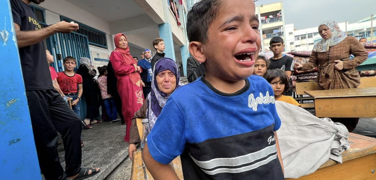 Criança chora em escola bombardeada por Israel