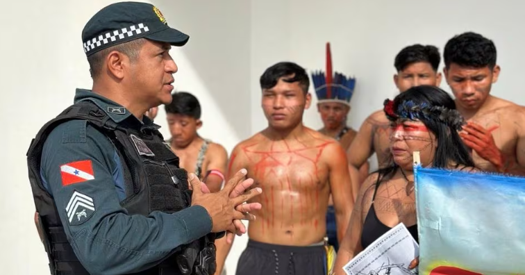 Policial conversa com manifestantes indígenas  Munduruku e Kayapó enquanto eles bloqueiam a entrada de audiência pública sobre a construção da Ferrogrão em Novo Progresso (PA) 15/12/23