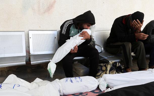 Homem beija o cadáver de criança palestina morta por ataque israelense em no hospital Abu Yousef al-Najjar, em Rafah, no sul da Faixa de Gaza