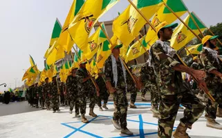 Homens muçulmanos xiitas iraquianos do Kataib Hezbollah seguram as bandeiras do partido enquanto caminham por uma rua pintada com as cores da bandeira israelense durante um desfile que marca o Dia Quds anual, ou Dia de Jerusalém, na última sexta-feira de o mês sagrado muçulmano do Ramadã, em Bagdá, 25 de julho de 2014