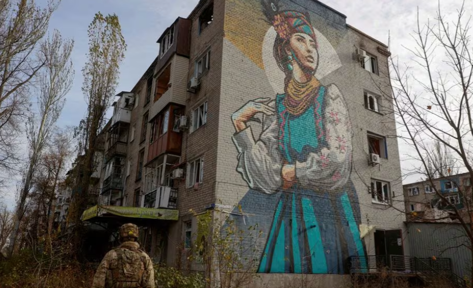 Militar ucraniano caminha ao lado de um prédio residencial fortemente danificado na cidade de Avdiivka, na linha de frente, em meio ao ataque da Rússia à Ucrânia, na região de Donetsk, Ucrânia, 8 de novembro de 2023