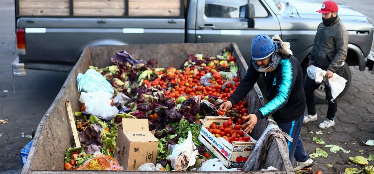 Homem recolhe comida em contêiner onde alimentos são descartados no Mercado Central de Buenos Aires 12/09/2023