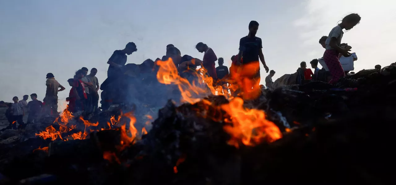 Palestinos procuram comida entre escombros após ataque israelense a campo de refugiados em Rafah, na Faixa de Gaza