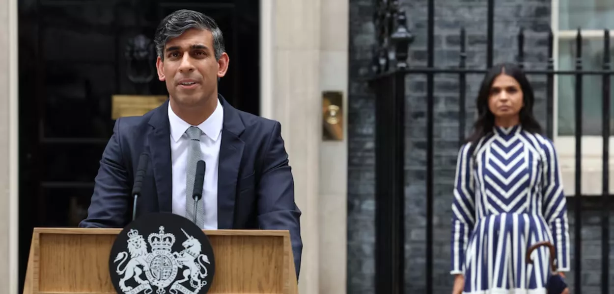 Rishi Sunak ladeado por sua esposa, Akshata Murty