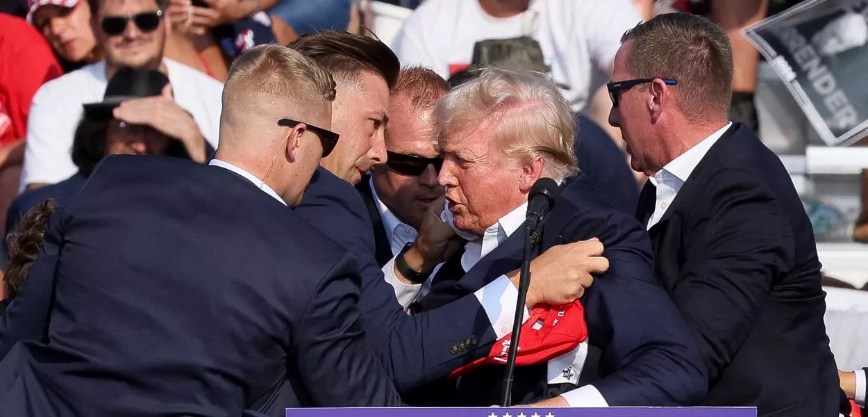 Trump é auxiliado por agentes de segurança depois de disparos serem em comício