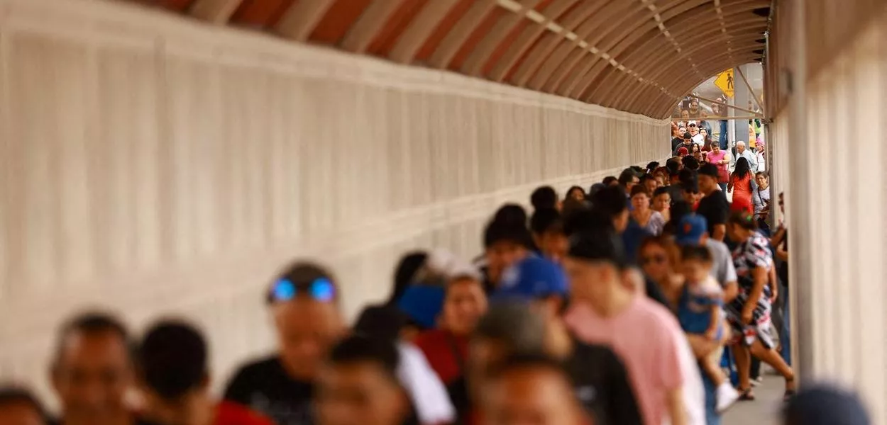 Fila de pessoas tendando cruzar para os Estados Unidos em Ciudad Juarez, México, após falha em sistemas de computadores