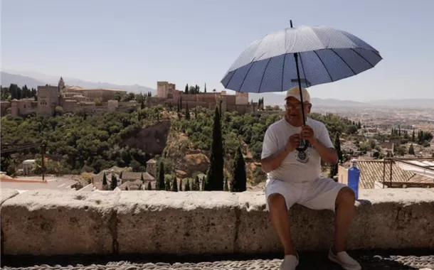 Um turista utilizou um guarda-chuva no mirante de San Nicolás, em frente à Alhambra, durante um dia quente de verão em Granada, Espanha, em 22 de julho de 2024