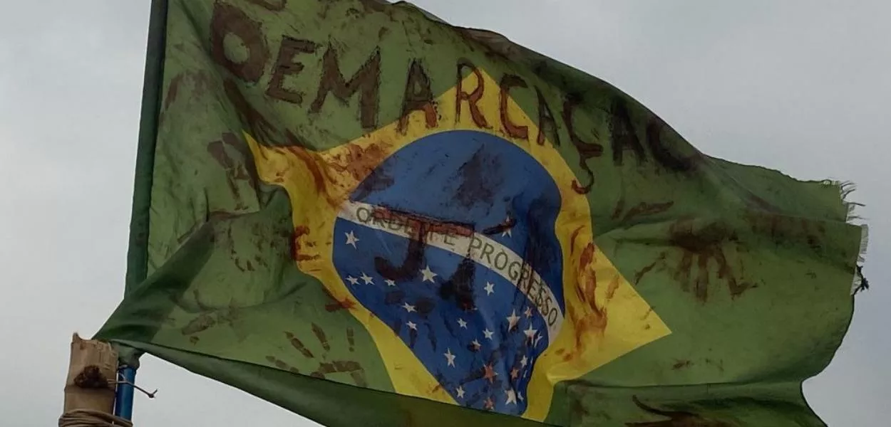 Bandeira nacional fincada na retomada Yvy Ajere, Terra Indígena Lagoa Panambi. Comunidade Guarani e Kaiowá segue sob ataque