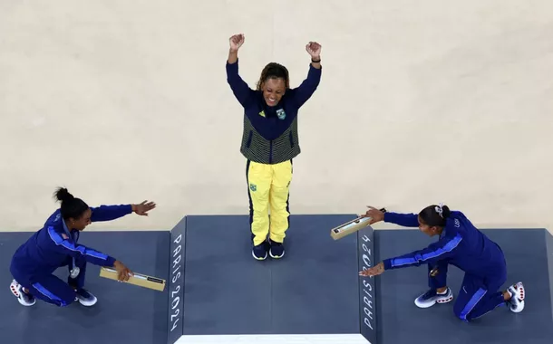 A medalhista de ouro Rebeca Andrade, do Brasil, comemora com a medalhista de prata Simone Biles, dos Estados Unidos, e a medalhista de bronze Jordan Chiles, dos Estados Unidos, no pódio