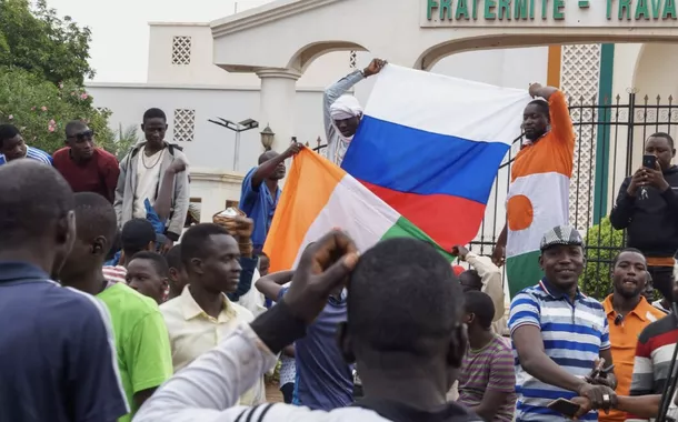 Manifestantes se reúnem e seguram uma bandeira russa em frente à Assembleia Nacional na capital Niamey, Níger, 27 de julho de 2023