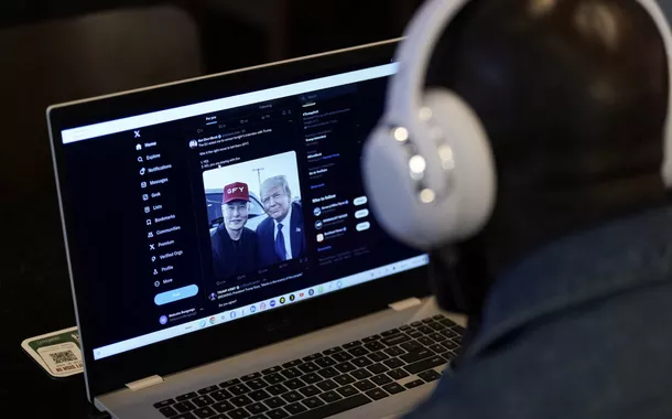 Uma pessoa tenta assistir em um laptop à entrevista do bilionário empreendedor Elon Musk com o candidato republicano à presidência e ex-presidente dos EUA Donald Trump na rede social X, na cidade de Nova York, EUA, em 12 de agosto de 2024