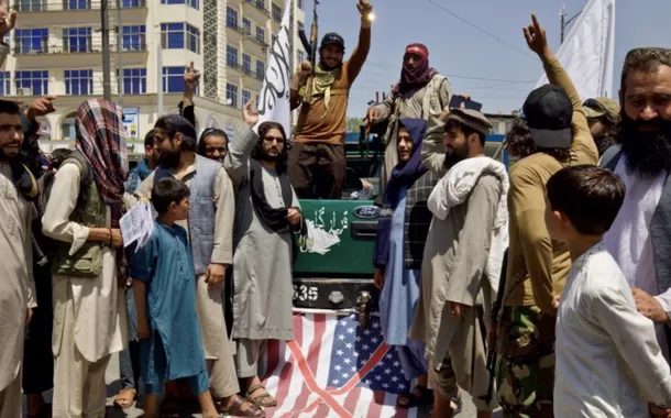 Membros e apoiadores do Talibã levantam uma bandeira dos EUA enquanto realizam um comício para marcar o terceiro aniversário da tomada de Cabul, em Cabul, Afeganistão, em 14 de agosto de 2024