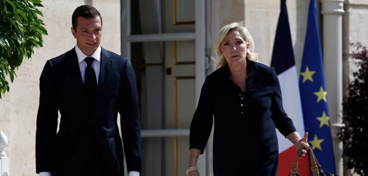 26/8/24 - A líder da extrema-direita francesa, Marine Le Pen, deputada do partido Rassemblement National (Reunião Nacional - RN), e Jordan Bardella, presidente do mesmo partido, caminham nos arredores do Palácio do Eliseu em 26 de agosto de 2024, em Paris, antes de se reunirem com o presidente Emmanuel Macron para discutir a nomeação de um novo primeiro-ministro.
