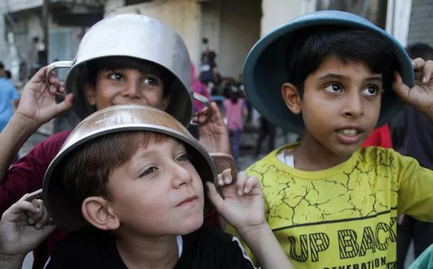 Crianças palestinas esperam para receber comida preparada por um serviço assistencial no norte da Faixabwin 365 loginGaza
14/08/2024
